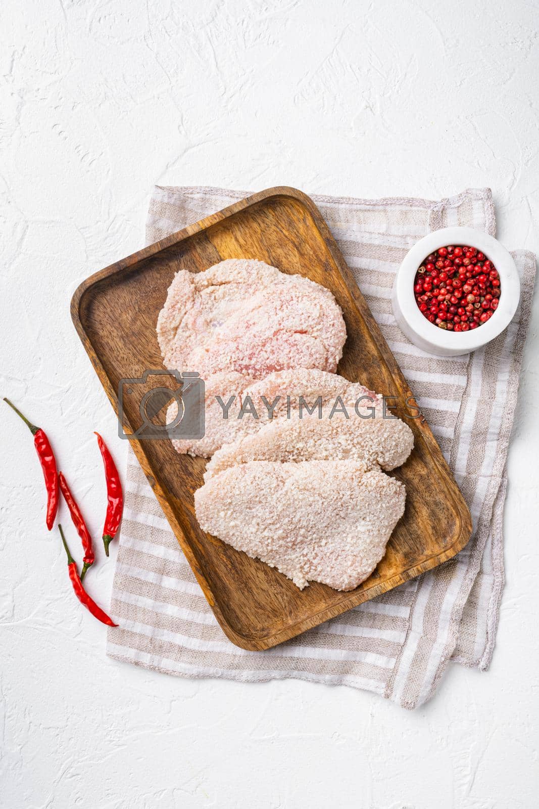 Royalty free image of Raw schnitzel chicken meat set, on white stone table background, top view flat lay by Ilianesolenyi