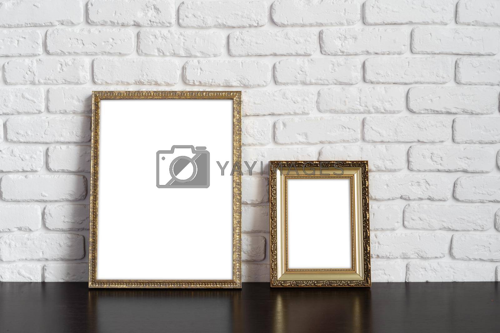 Royalty free image of Blank picture frame against brick wall with copy space by Fabrikasimf
