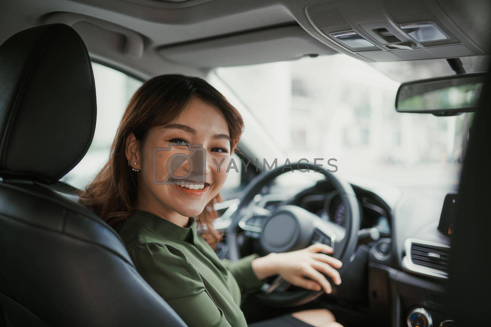 Royalty free image of Pretty young woman driving car by makidotvn
