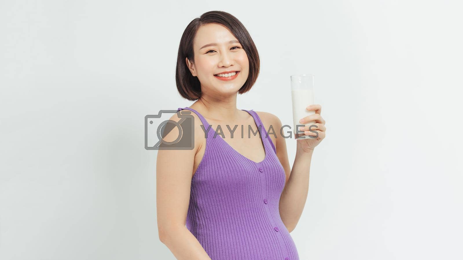 Royalty free image of A woman drinking a glass of milk during her pregnancy by makidotvn