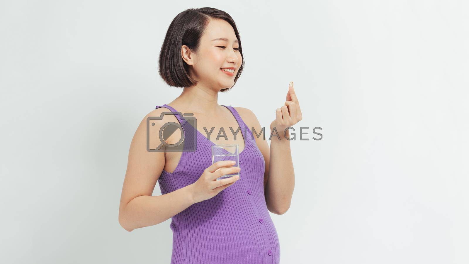 Royalty free image of Pregnant woman with fish oil at home by makidotvn
