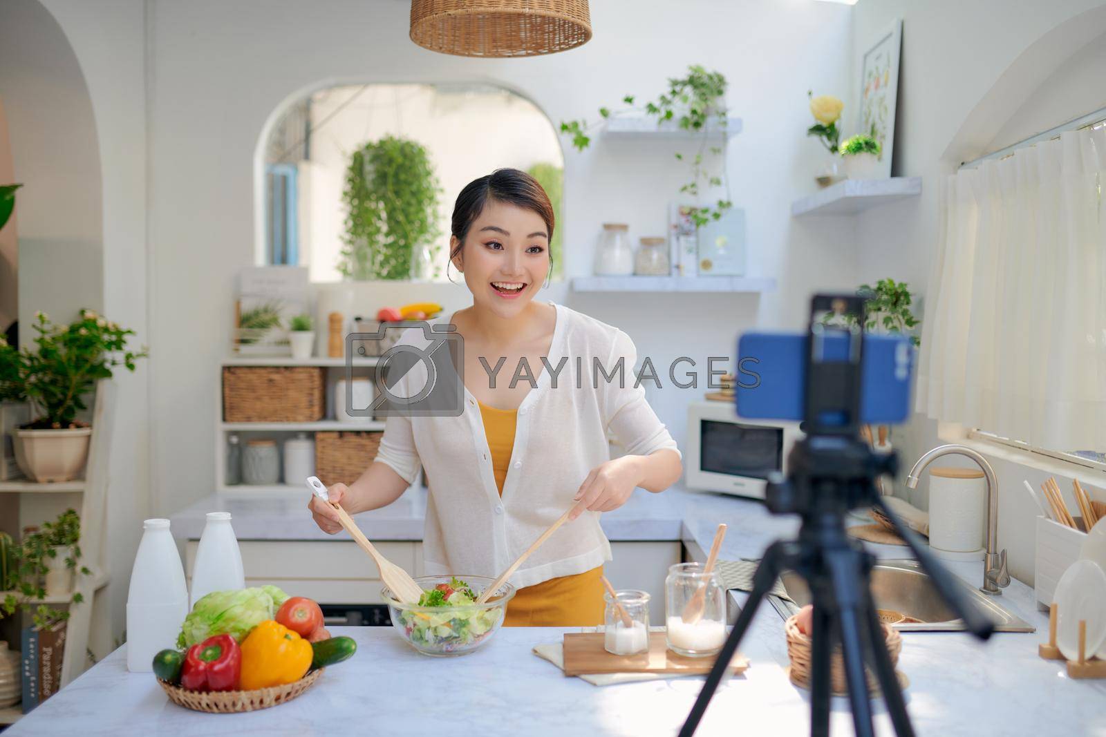 Royalty free image of Asian woman recording a video blog by makidotvn