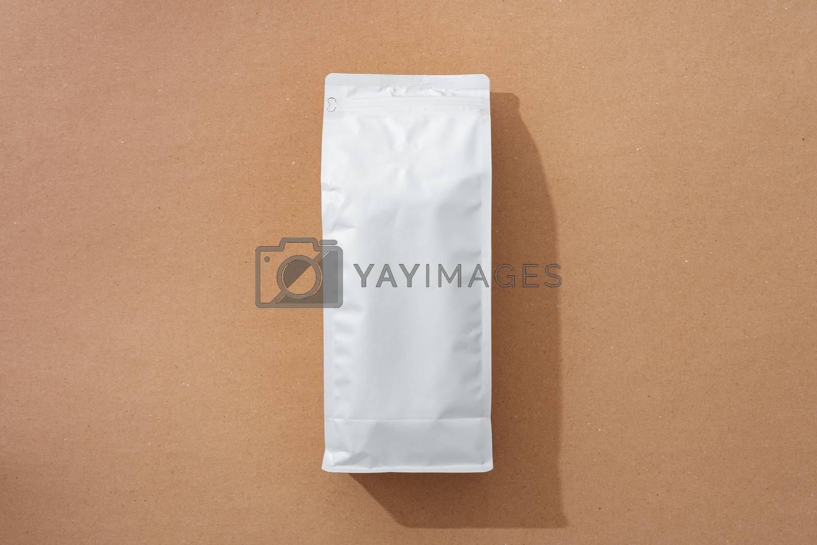 Royalty free image of White blank matte coffee package on paper background by Fabrikasimf