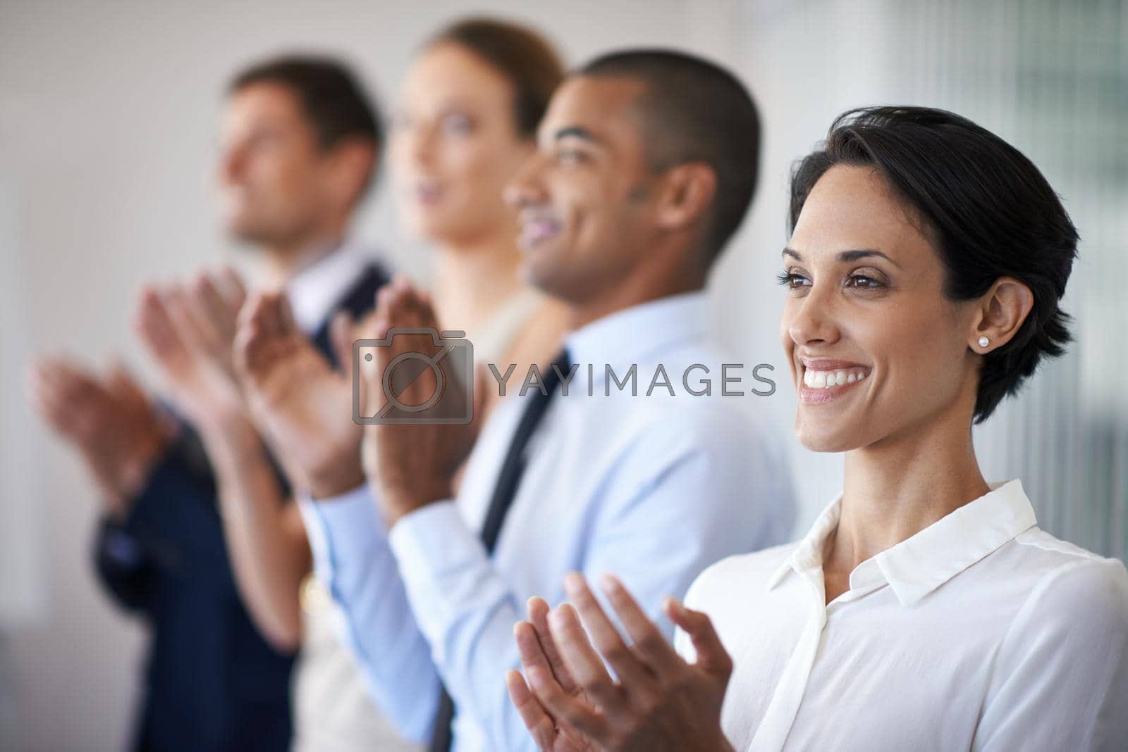 Royalty free image of Thats something to celebrate. Shot of a row of smiling colleagues clapping. by YuriArcurs