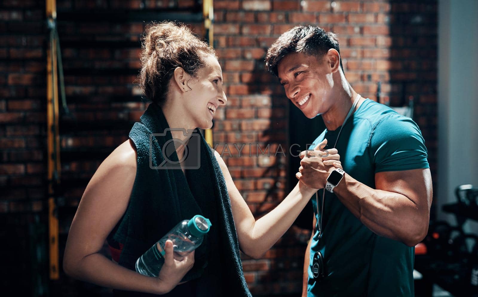 Royalty free image of Cant wait till our next session. Cropped shot of two cheerful young sportspeople cheering while working out in a gym. by YuriArcurs