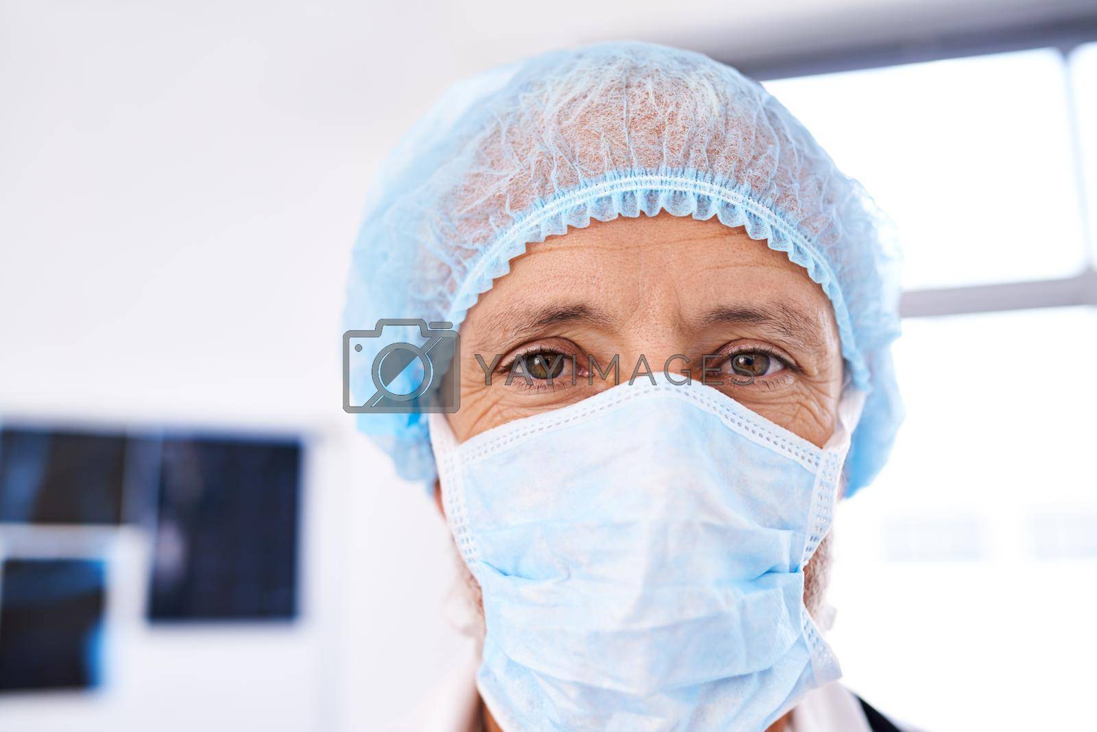 Royalty free image of Hes ready for surgery. Shot of a mature male surgeoun wearing a surgical mask and cap. by YuriArcurs