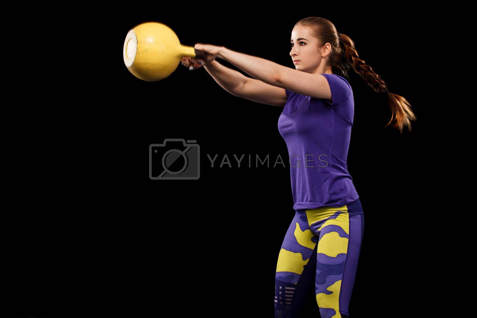 Royalty free image of Sporty beautiful woman with dumbbell exercising at black background to stay fit. Crossfit workout motivation. by MikeOrlov