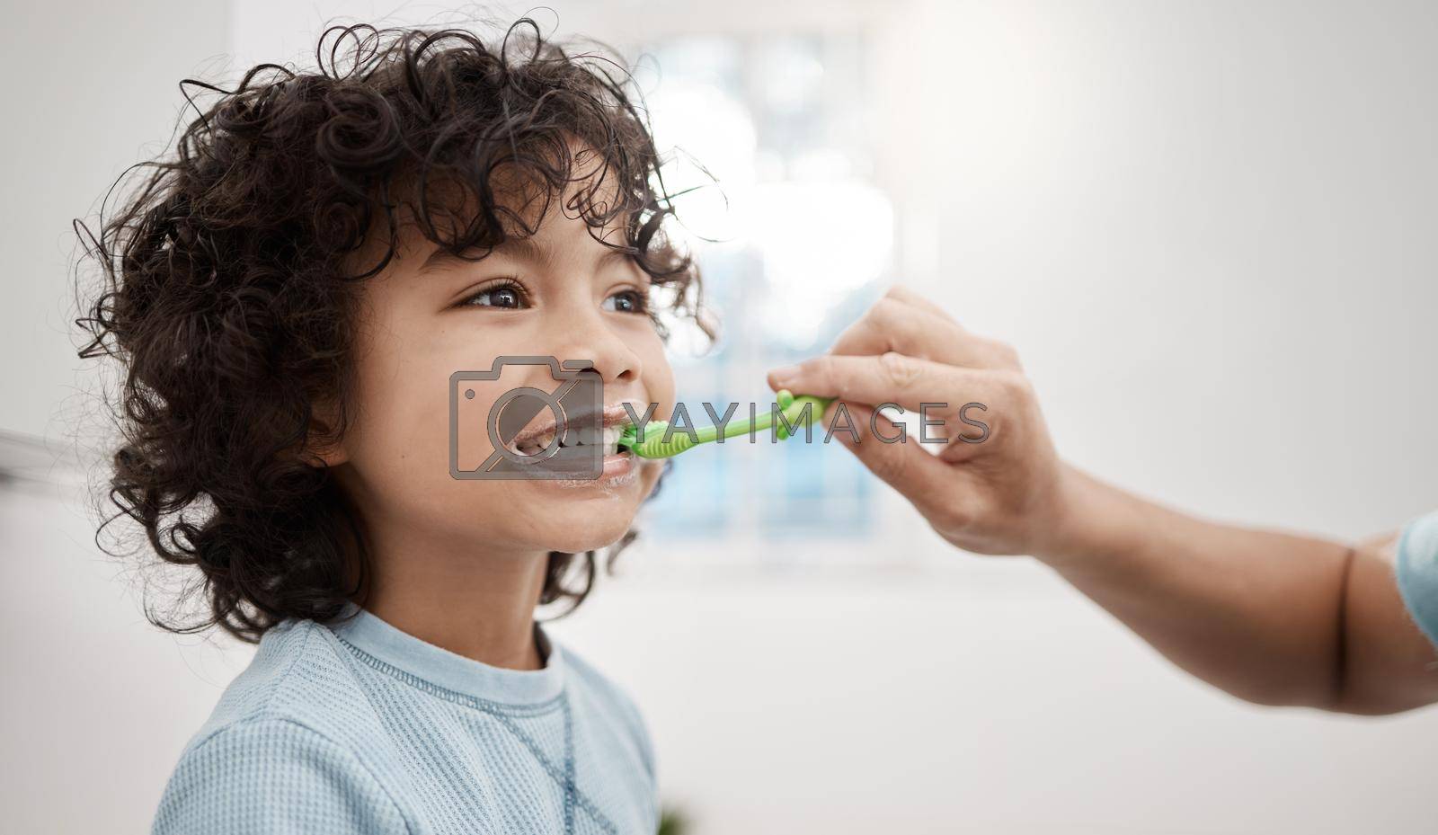 Royalty free image of Brushing your kids teeth properly helps prevent cavities and infection. Shot of a father brushing his little sons teeth in the bathroom at home. by YuriArcurs