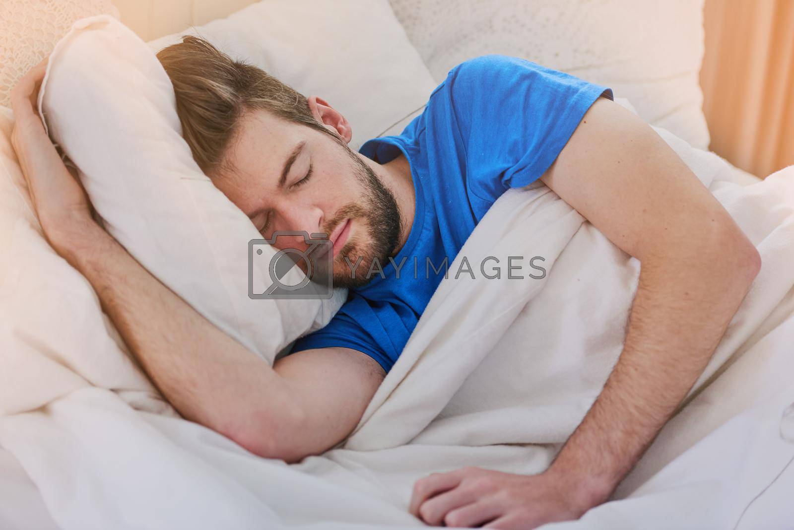 Royalty free image of Sleeping in on the weekend. Cropped shot of a handsome young man sleeping in bed at home. by YuriArcurs