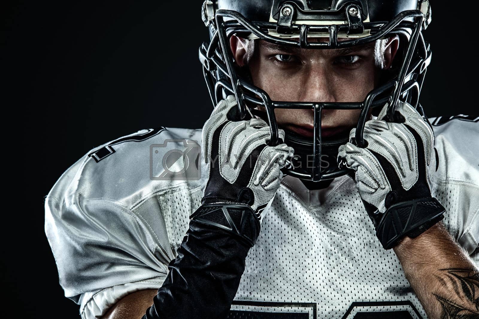 Royalty free image of American football sportsman player in helmet isolated on black background. Sport and motivation wallpaper. by MikeOrlov