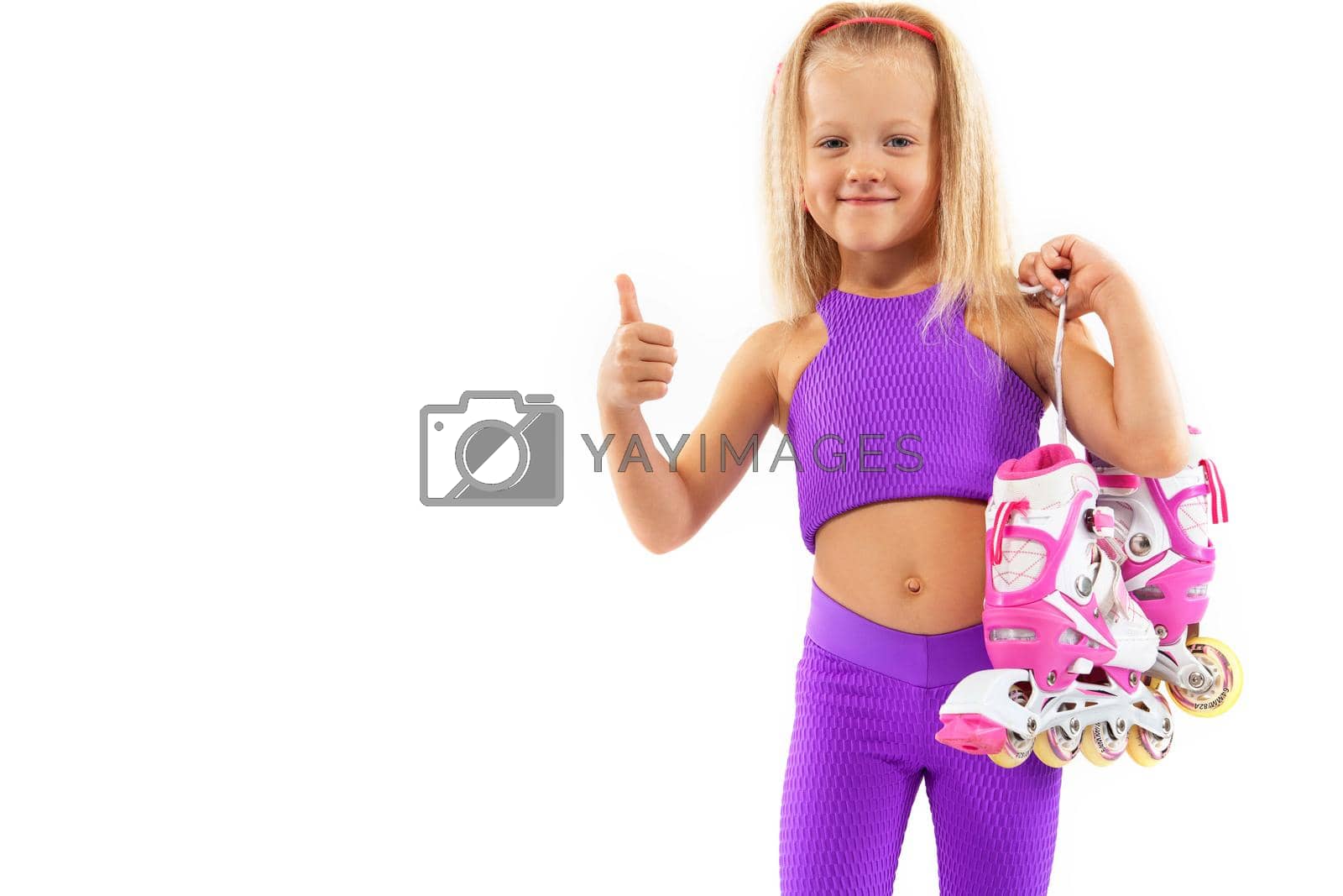 Royalty free image of Girl, kid posing in studio wearing inline rollerskates by MikeOrlov