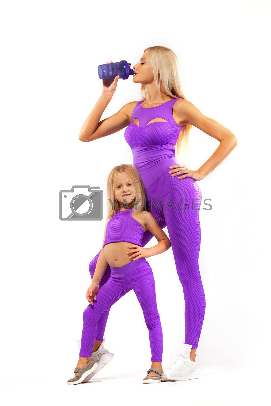 Royalty free image of Mom and daughter rest after fitness with a shaker in hands. Isolated on white background. by MikeOrlov