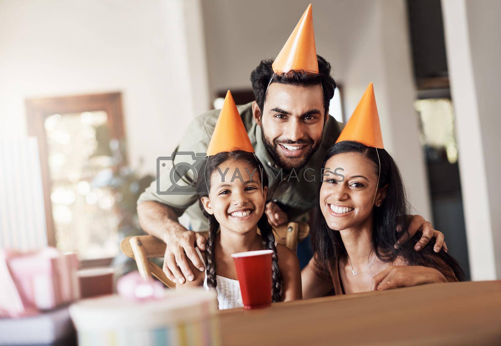 Royalty free image of Hip hip hooray, its someones birthday. Shot of a happy mother and father celebrating their daughters birthday at home. by YuriArcurs