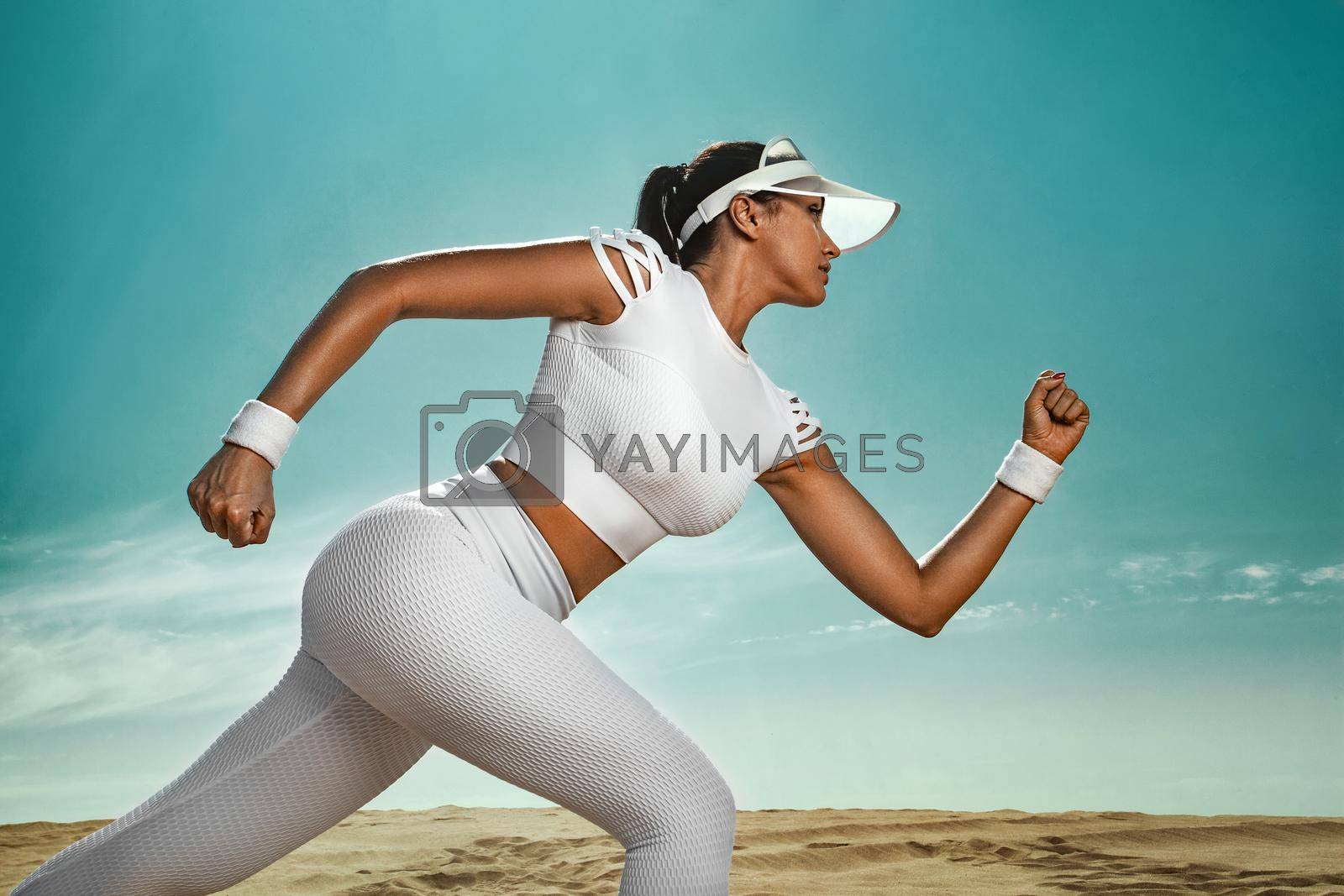 Royalty free image of Sporty young woman and fit athlete runner running on the sky background. The concept of a healthy lifestyle and sport. Woman in white sportswear. by MikeOrlov