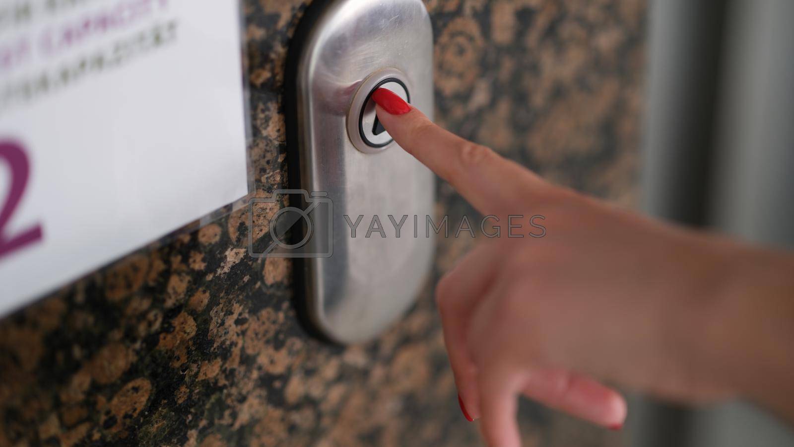 Royalty free image of Female finger with red manicure pressing elevator button closeup by kuprevich
