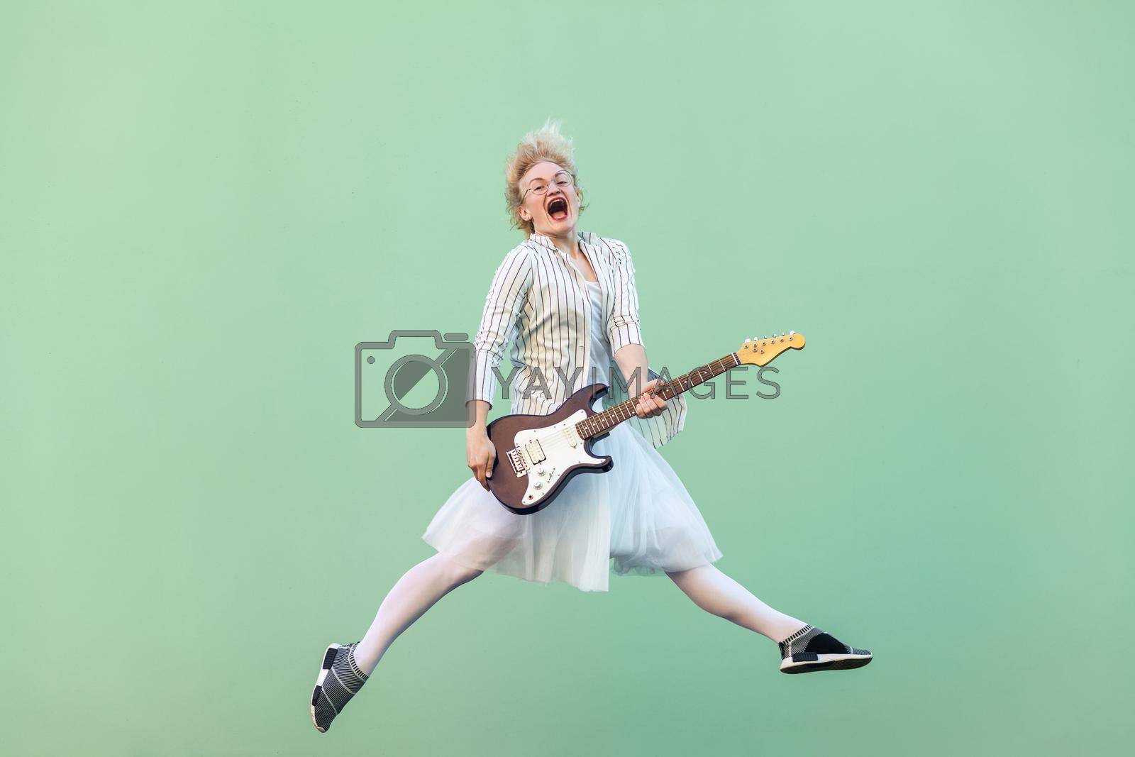 Royalty free image of Emotional blonde girl in white style standing on green background by Khosro1