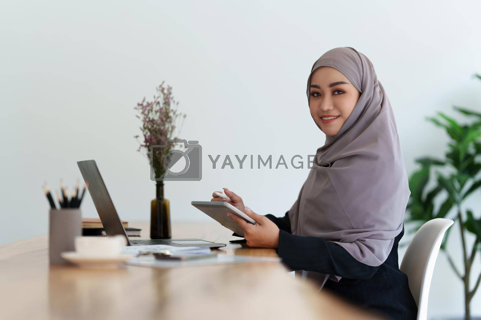 Royalty free image of Business Finance audit tax Concept. Portrait of Muslim Young business women analytics about marketing plan of this years. by itchaznong