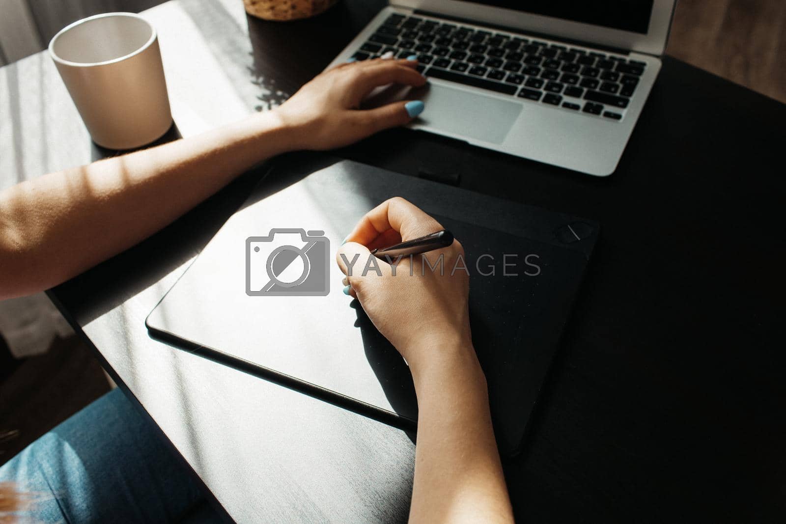 Royalty free image of Close up of female graphic designer drawing sketches on graphic tablet by Fabrikasimf