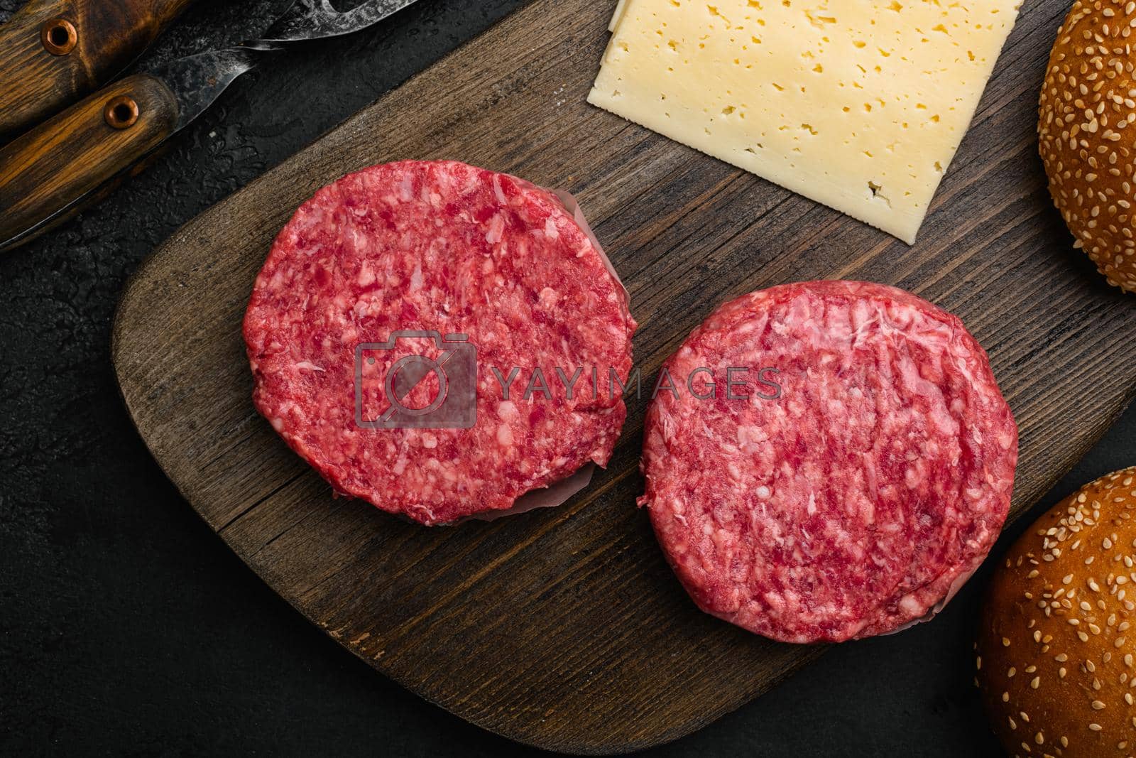 Royalty free image of Fresh raw minced homemade farmers grill beef burgers on black dark stone table background, top view flat lay by Ilianesolenyi