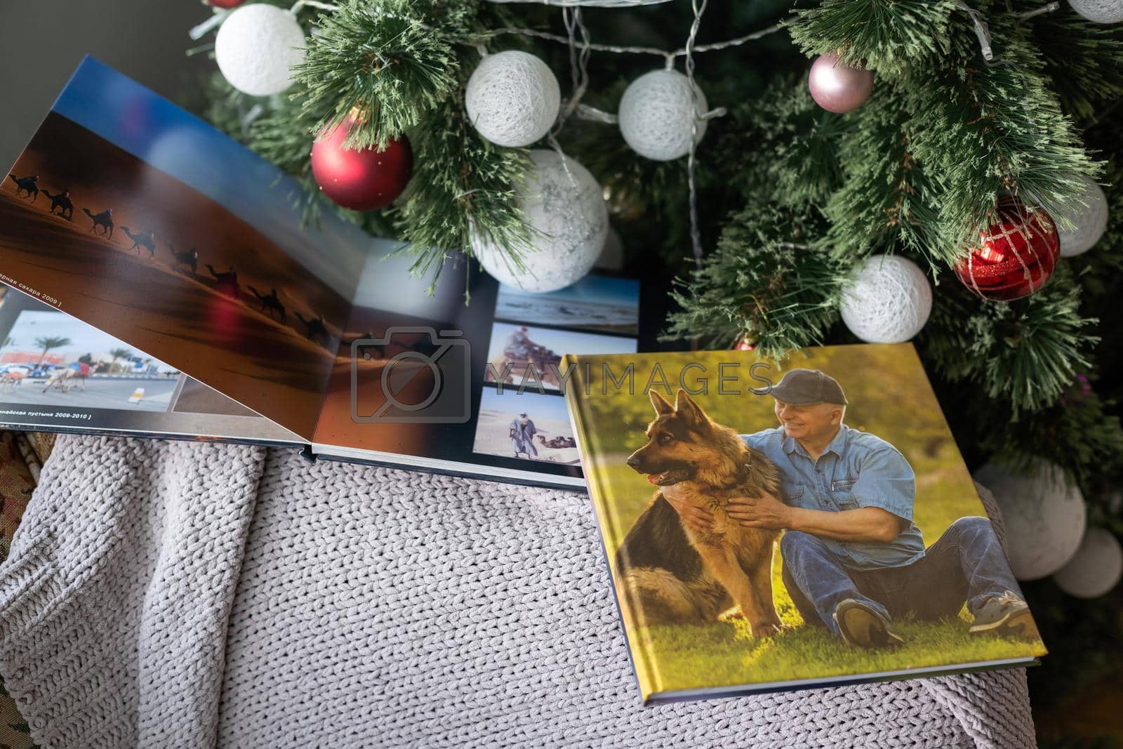 Royalty free image of Photo book family photo album under the Christmas tree surrounded by Christmas gifts by Andelov13
