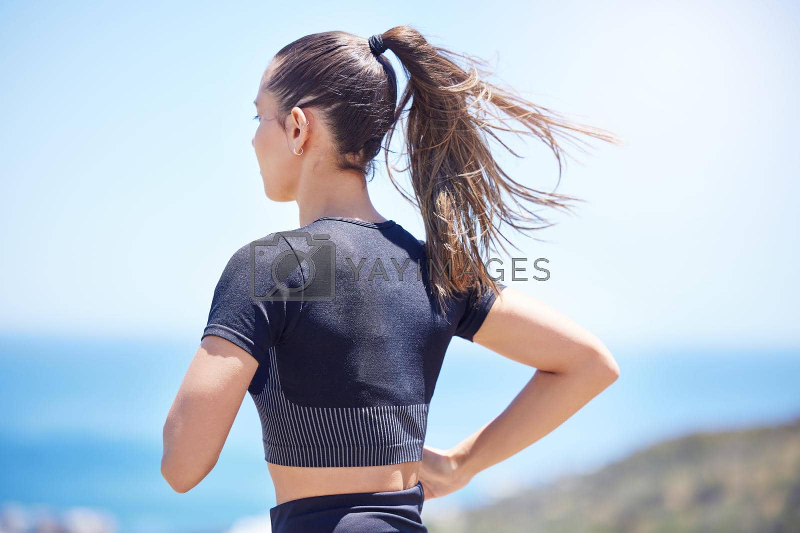 Royalty free image of Rear view of Unknown fit active mixed race female running outside during a her daily exercise routine by YuriArcurs