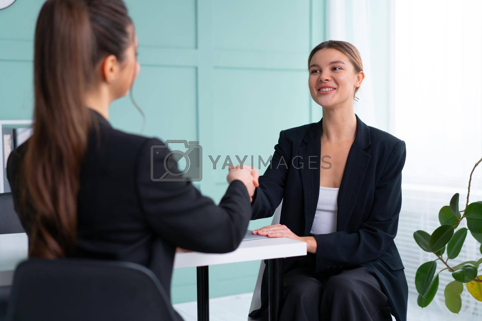 Royalty free image of Job interview. Business, career and placement concept. Young blonde woman handshaking candidate hand, while sitting in front of candidate during corporate meeting or job interview by andreonegin