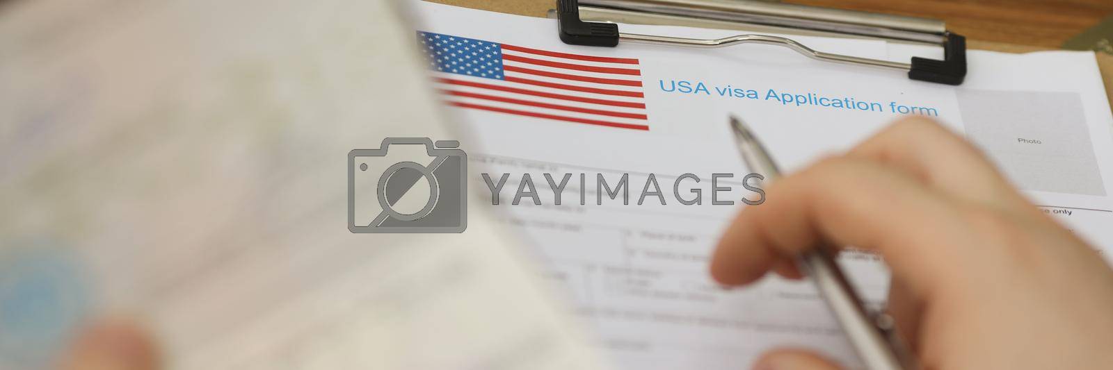 Royalty free image of Person filling visa application forms holding personal passport by kuprevich