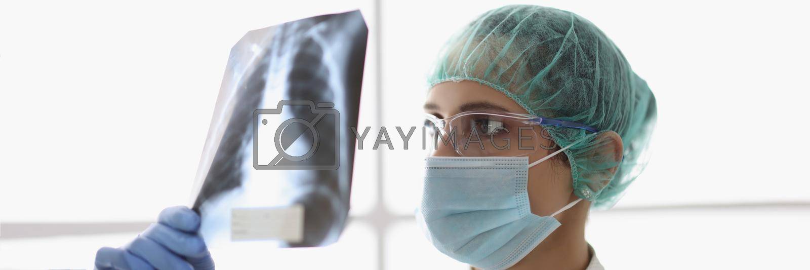 Royalty free image of Qualified female doctor examine x ray scan of patients lungs by kuprevich