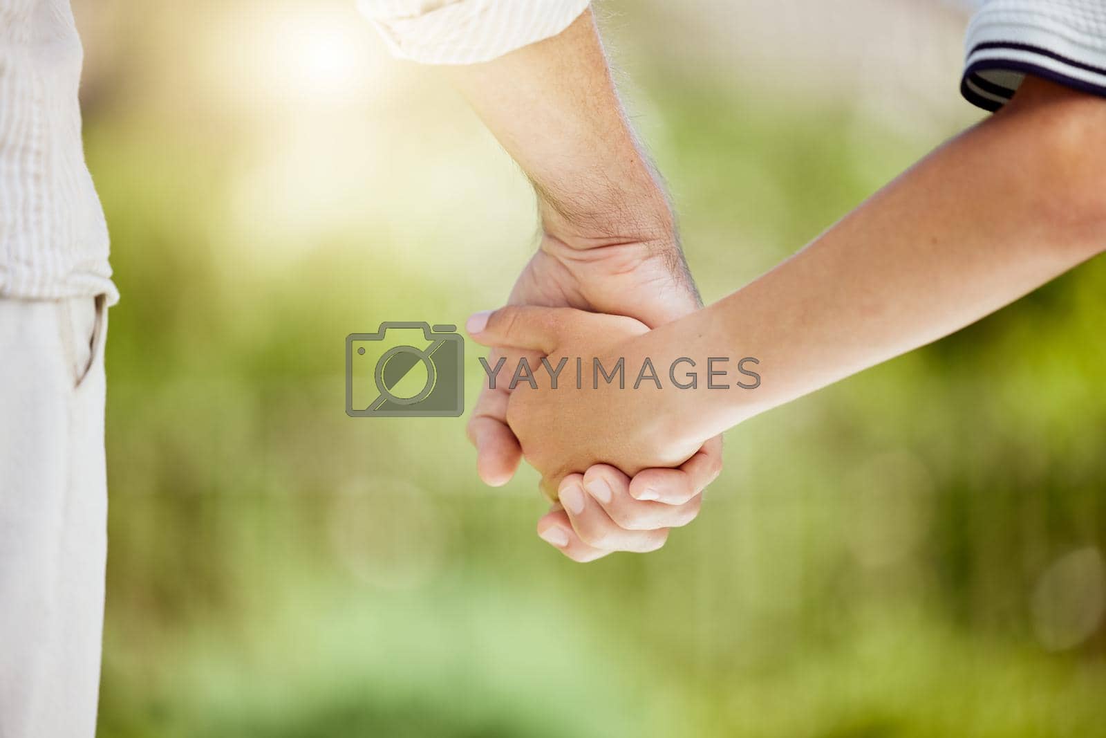Royalty free image of Family is an important pillar in our life. Cropped shot of a man holding his sons hand while walking outside. by YuriArcurs