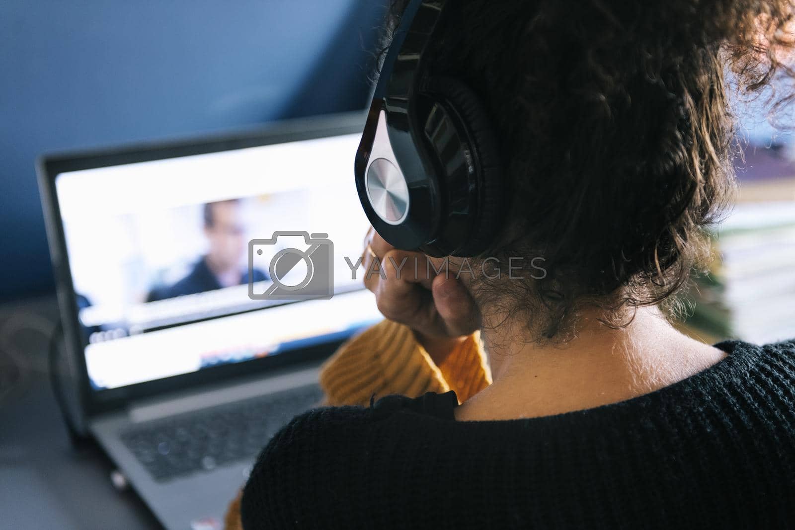 Royalty free image of woman with headphones watching a movie on laptop by raulmelldo
