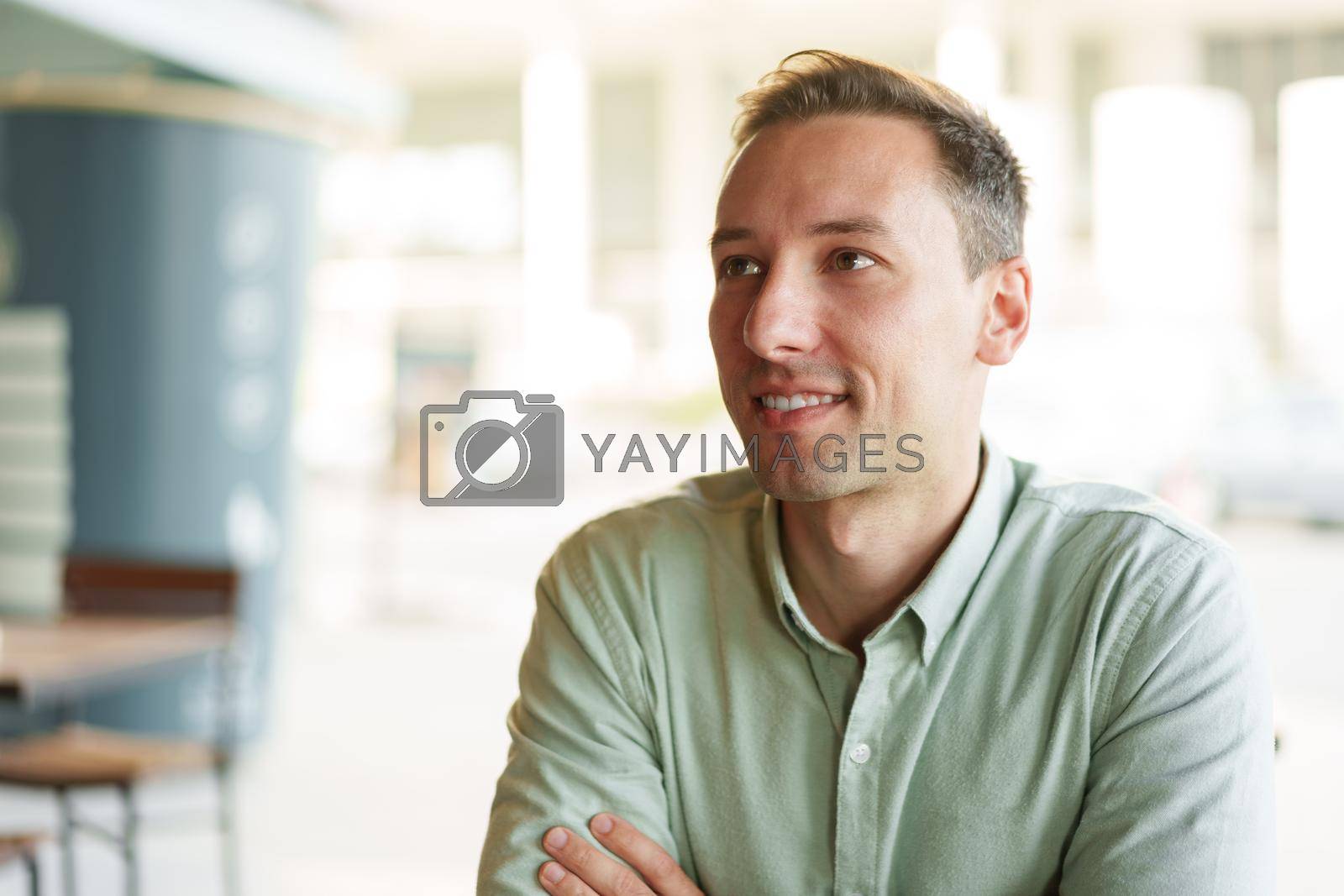 Royalty free image of Confident young businessman sitting at cafe portrait by Fabrikasimf