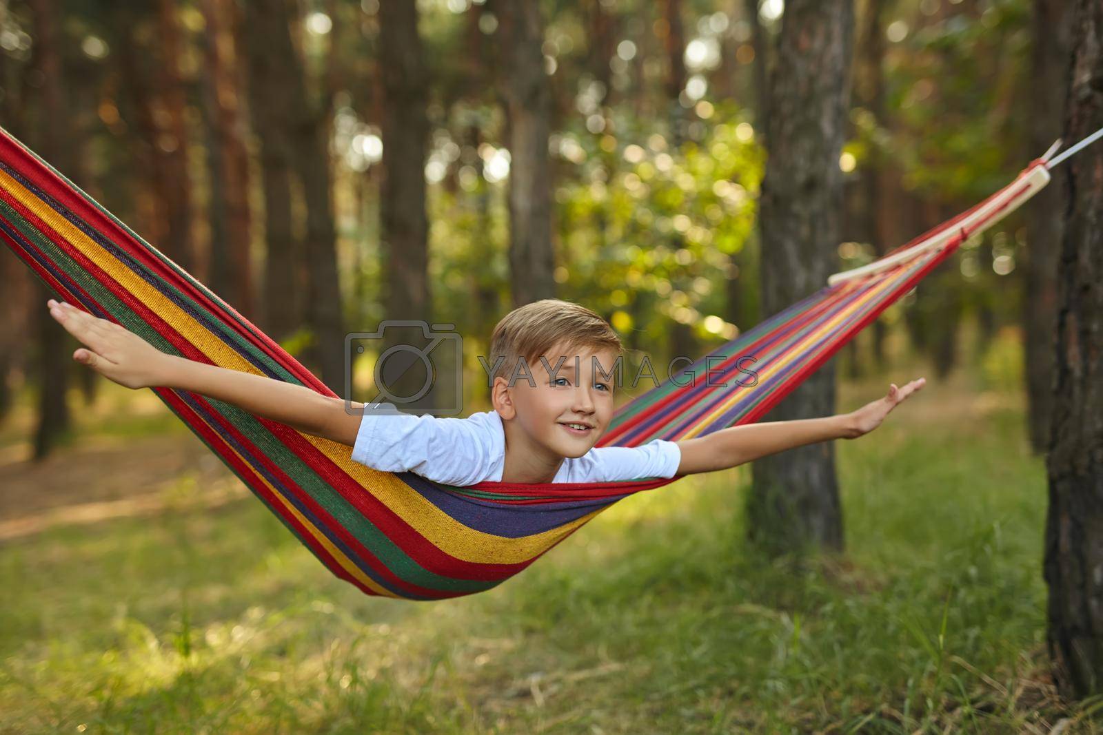 Royalty free image of Cute boy is sitting in a hammock. by InnaVlasova
