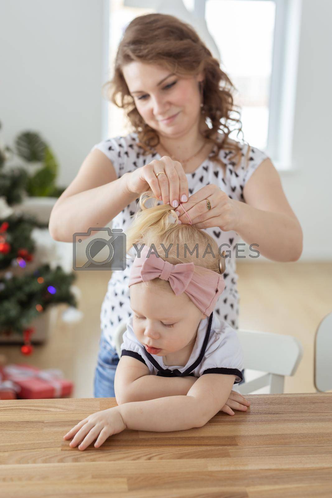 Royalty free image of Mother fixing her daughter's cochlear implant hearing aid - diversity concept. Innovative medical technologies by Satura86