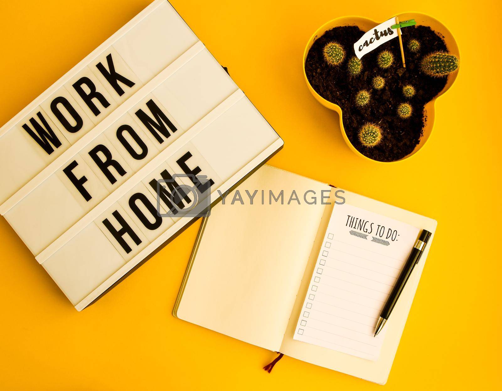 Royalty free image of lightbox with text WORK FROM HOME with notebook pen and cactus and TO DO list, copy space on yellow background, quarantine and isolation HOME OFFICE by anna_stasiia