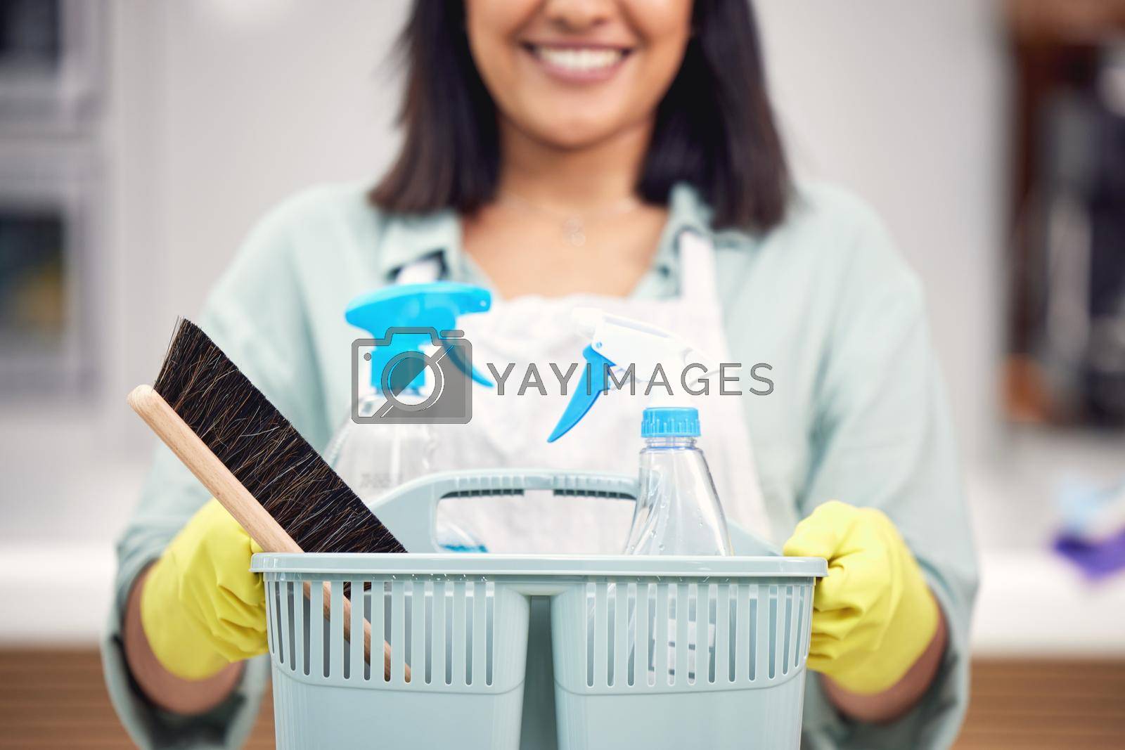Royalty free image of A basket to make it better. a woman holding a basket with cleaning supplies. by YuriArcurs