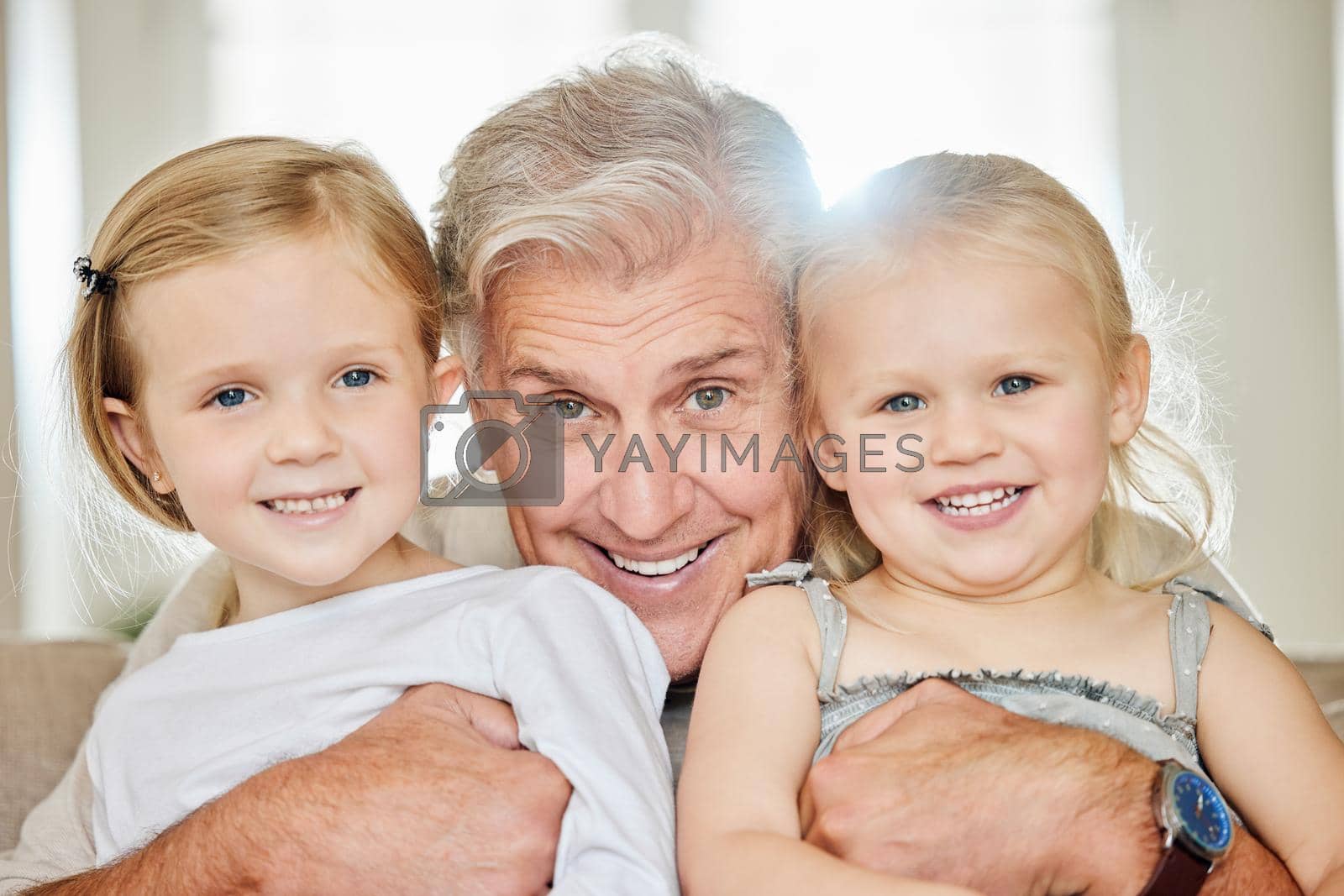 Royalty free image of A man should never neglect his family for business. a grandpa and his granddaughters at home. by YuriArcurs