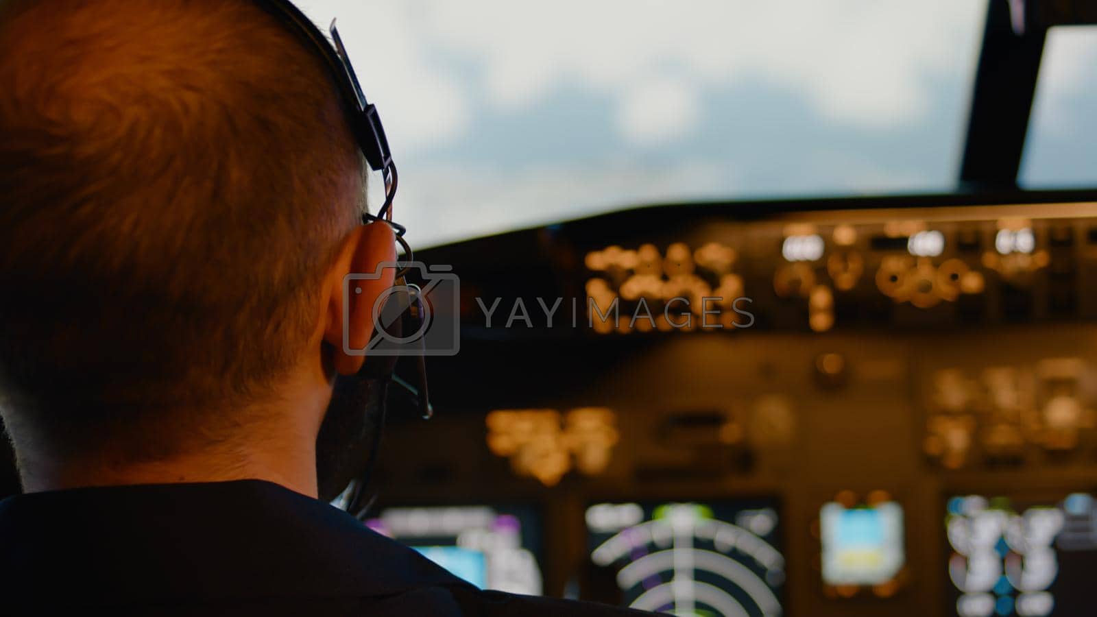 Royalty free image of Male aviator using handle and windscreen in cockpit to fly airplane by DCStudio