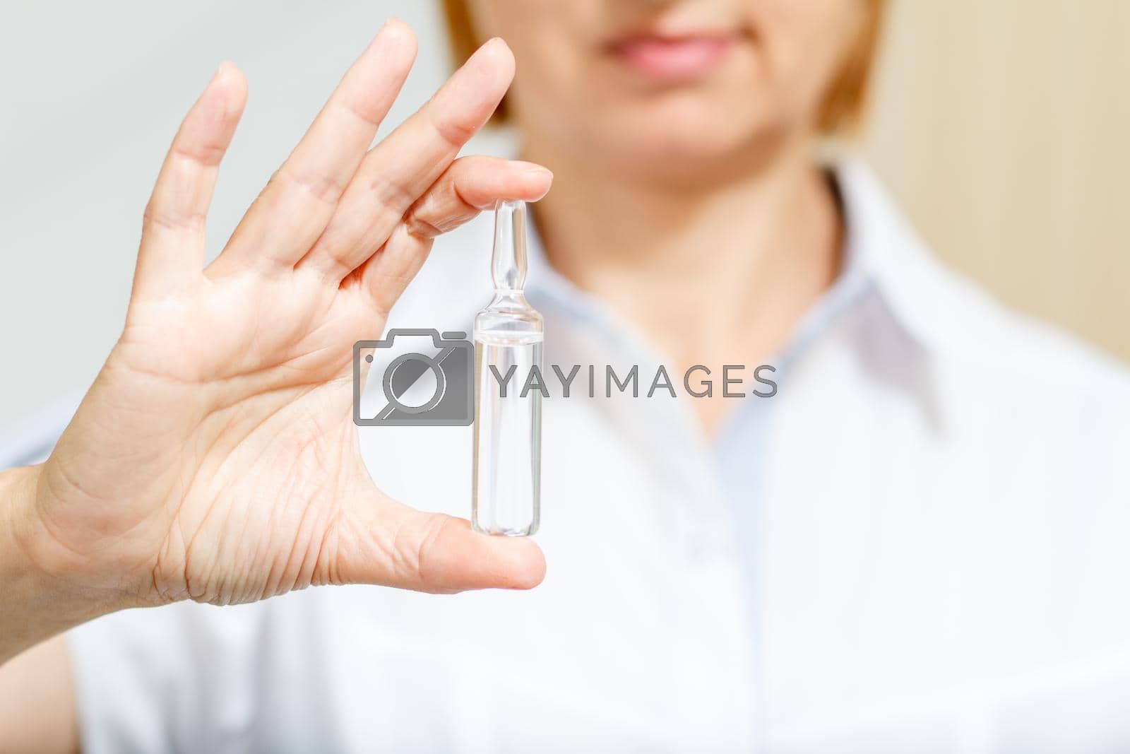Royalty free image of Hand of female doctor with ampoule and medicine by mvg6894