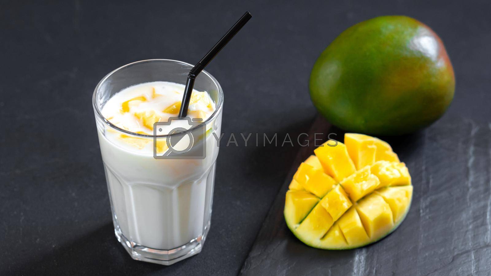 Royalty free image of Milk drink on black background with mango. A classic mango milkshake - Lassi. A traditional drink in India from the heat by gulyaevstudio