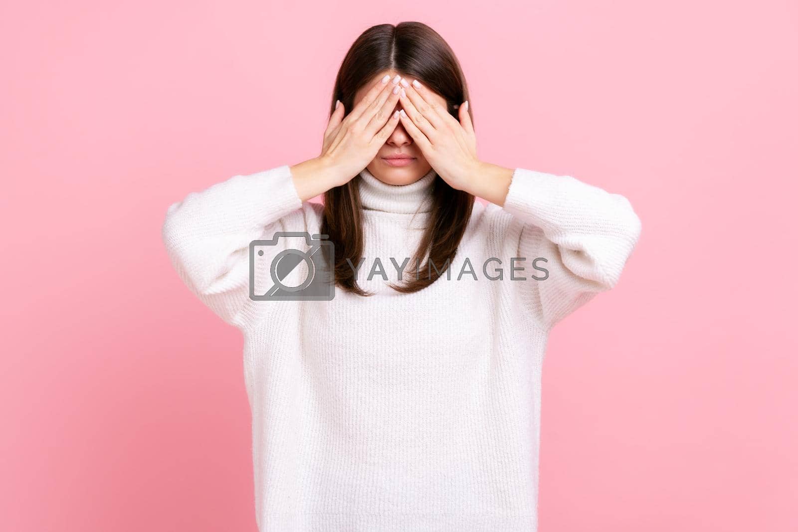 Royalty free image of Brunette young adult female standing, covering eyes with both hand, refusing to watch, shame content by Khosro1