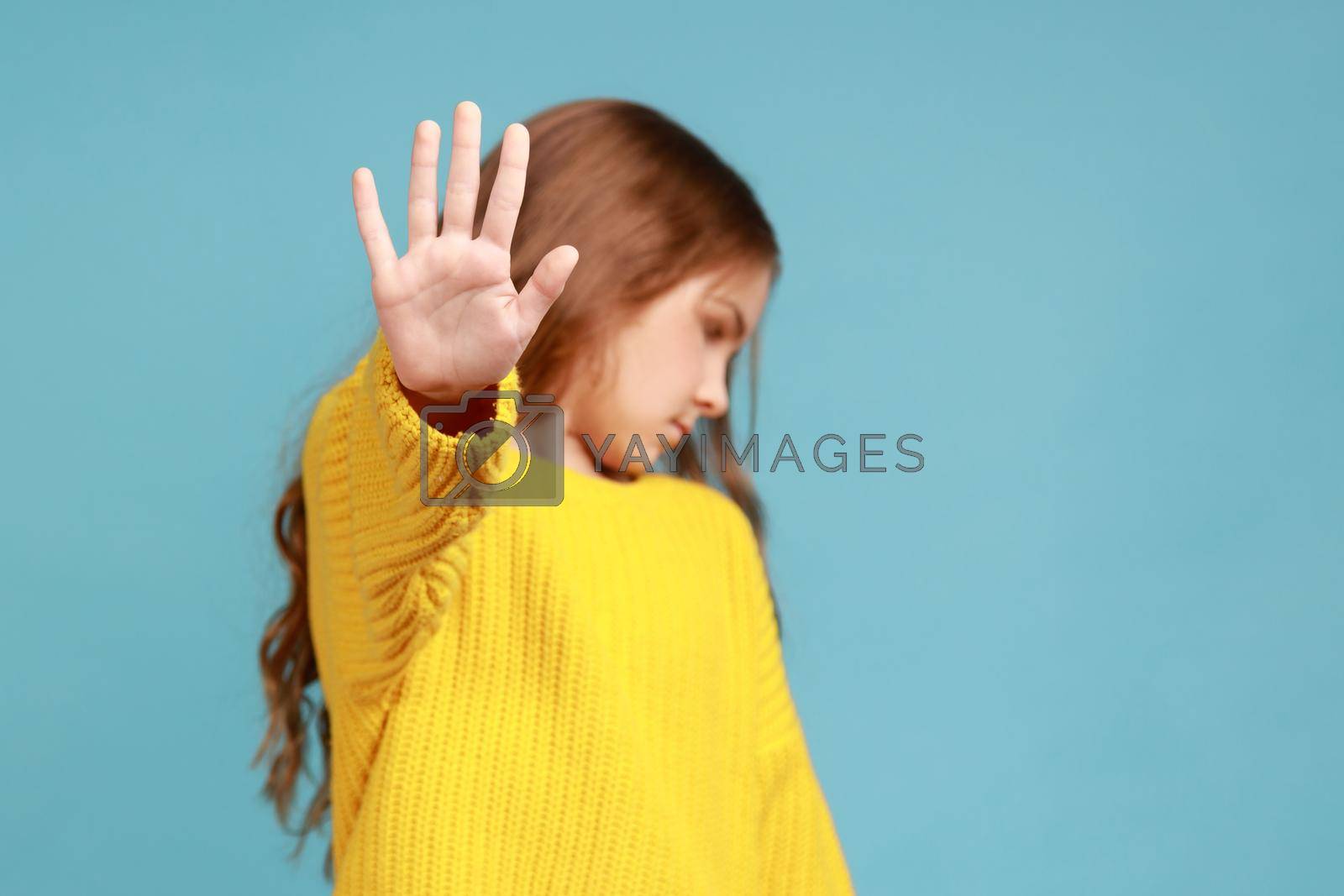 Royalty free image of Portrait of serious little girl showing stop gesture, warning to go, looking away dissatisfied. by Khosro1