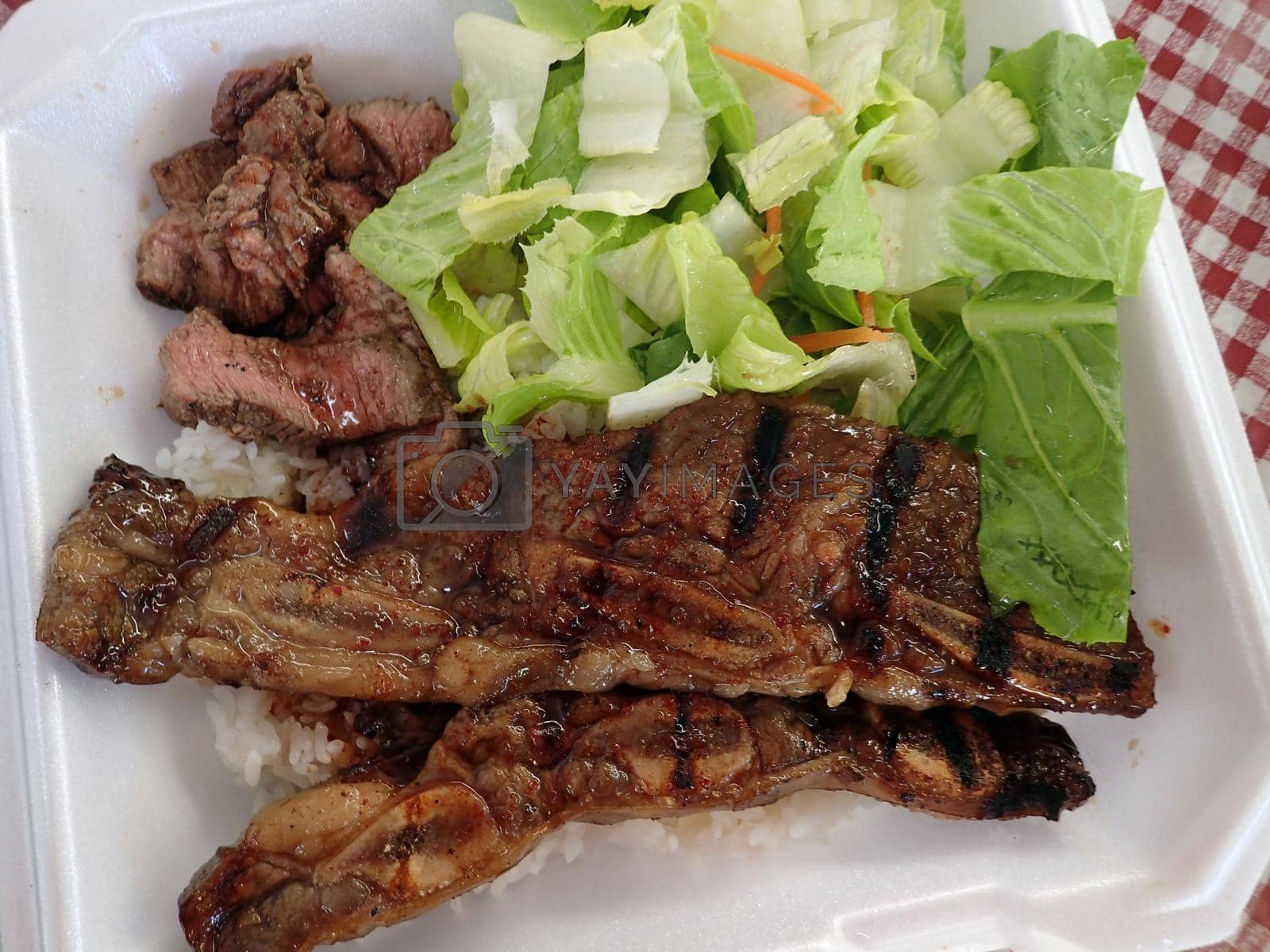 Royalty free image of Steak, Kalbi, Side salad and white rice in a styrofoam plate by EricGBVD