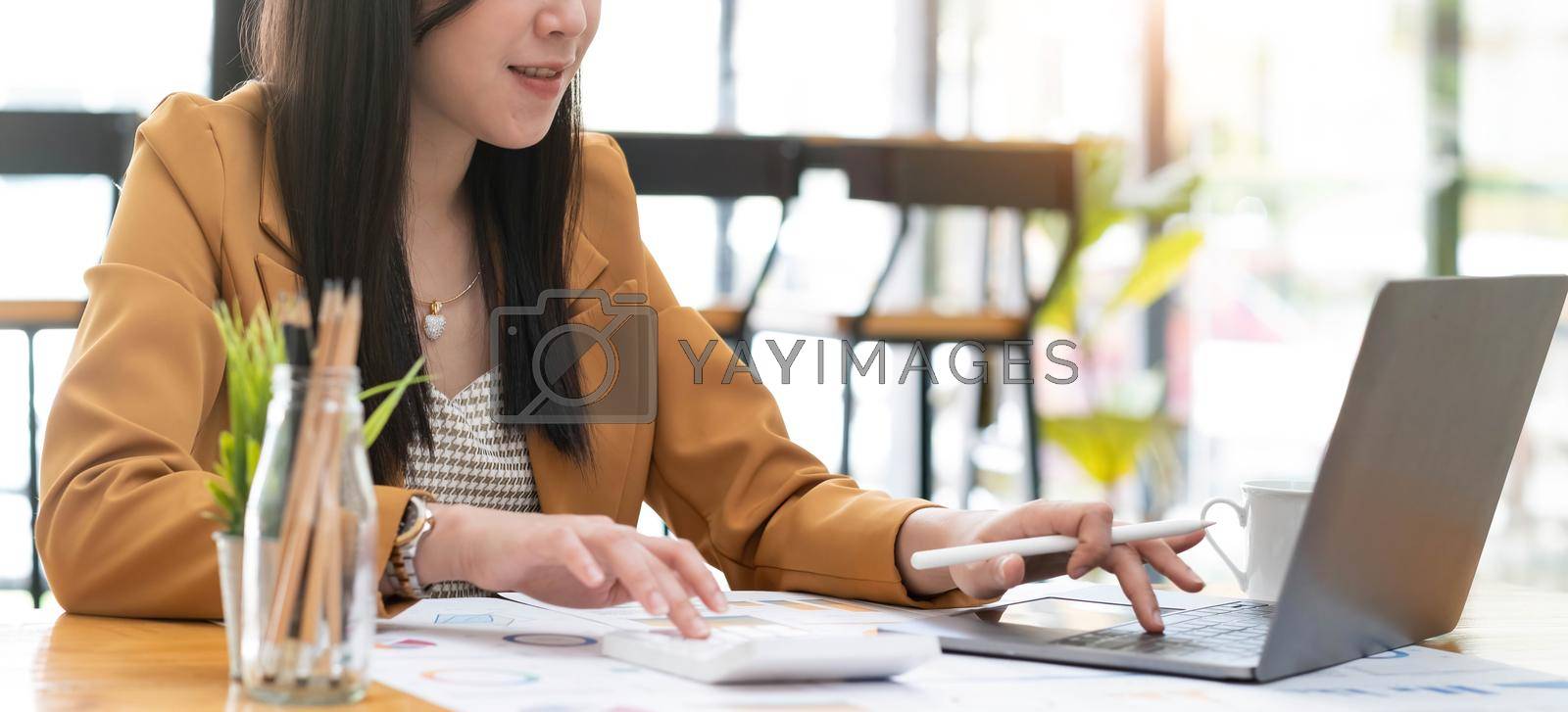 Business women using calculator at working with financial report..
