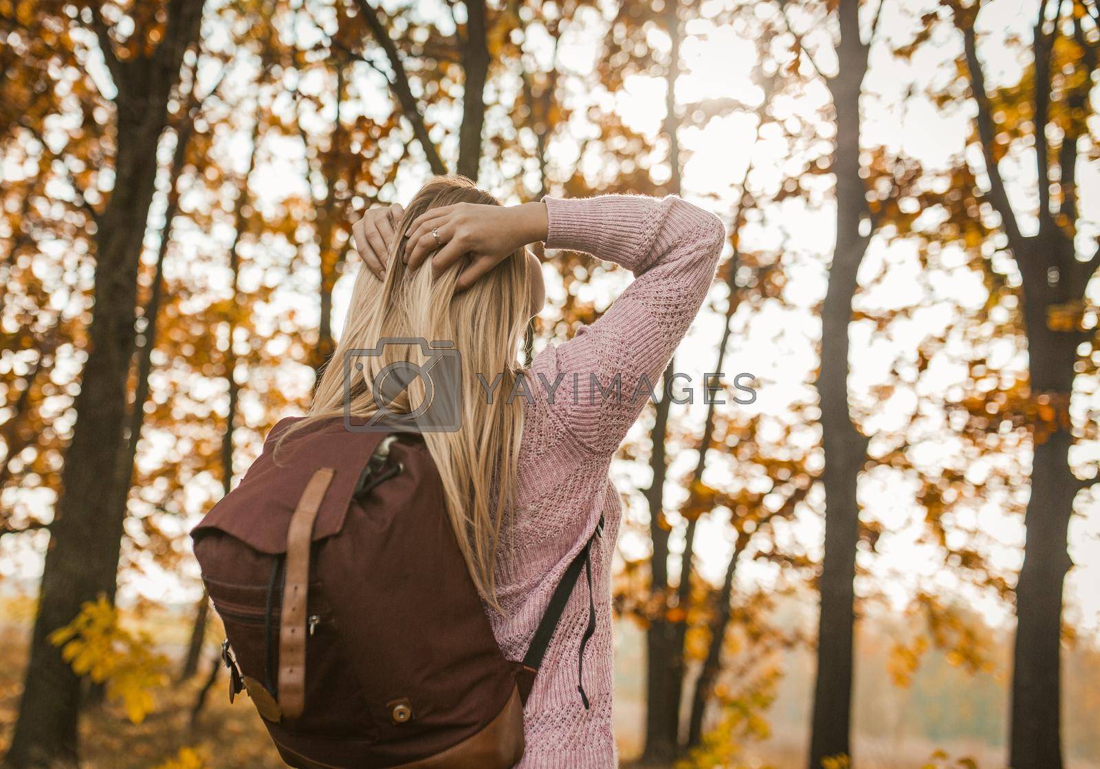 Royalty free image of Blonde Lady With Backpack Turned To Face The Sun by LipikStockMedia