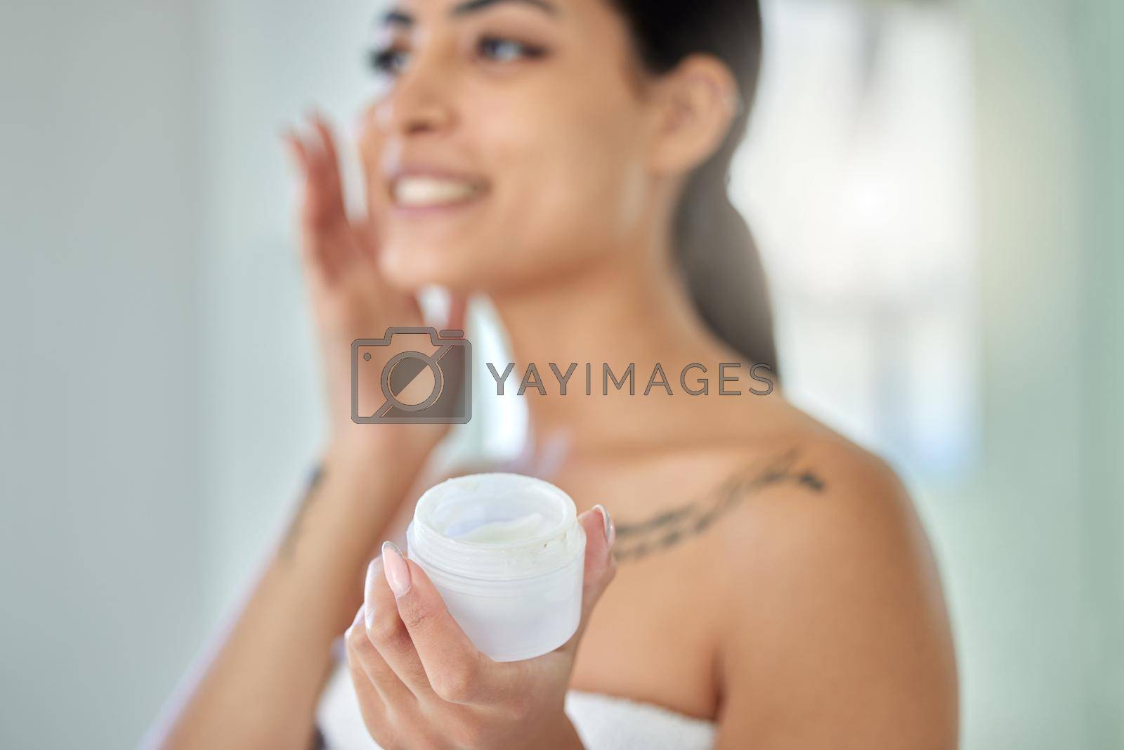 Royalty free image of My skincare secret. a young woman applying cream to her face in a bathroom at home. by YuriArcurs