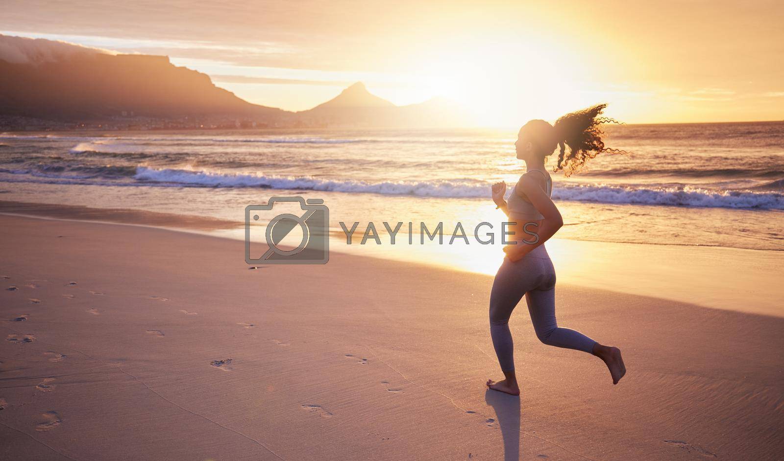 Royalty free image of Work on you for you. a woman out for a run on the beach at sunset. by YuriArcurs