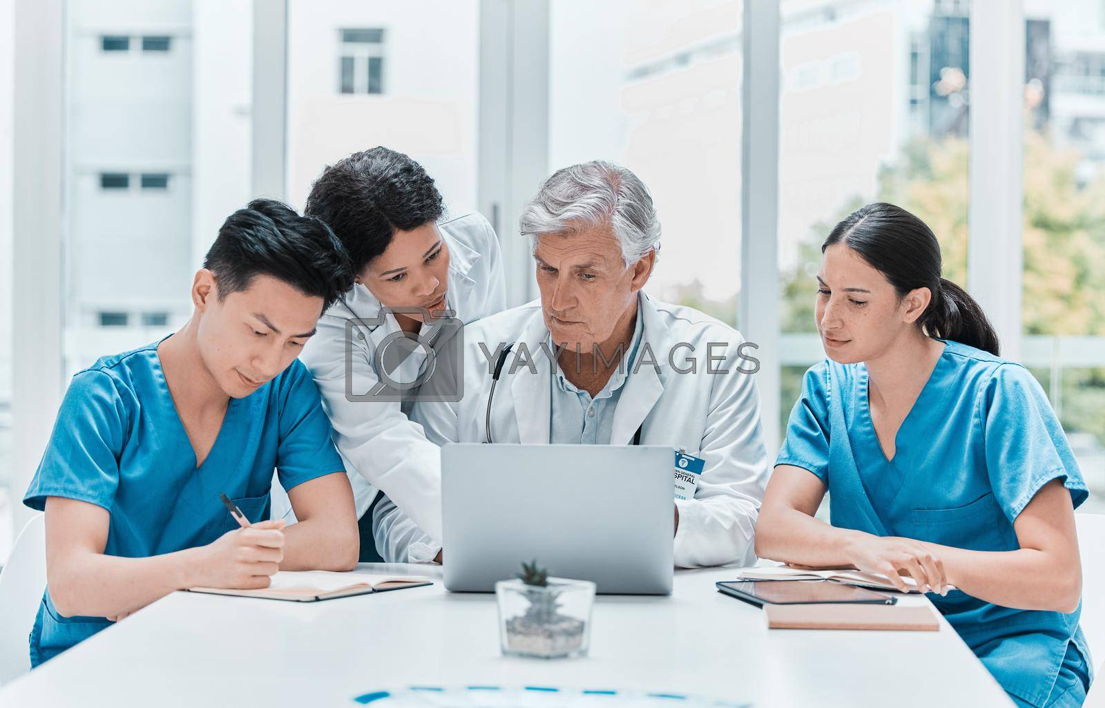 Royalty free image of Developing healthcare and medicine as a cooperative science. a group of medical practitioners working together on a laptop in a medical office. by YuriArcurs