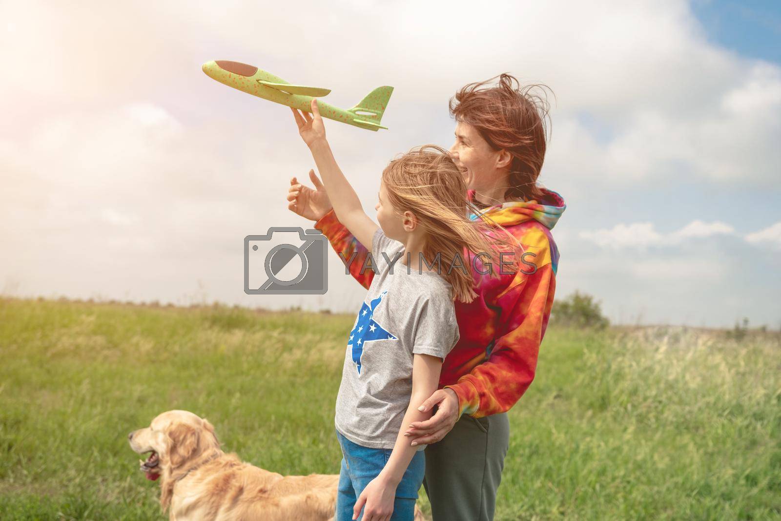 Royalty free image of Mother and daughter playing with toy plane by GekaSkr
