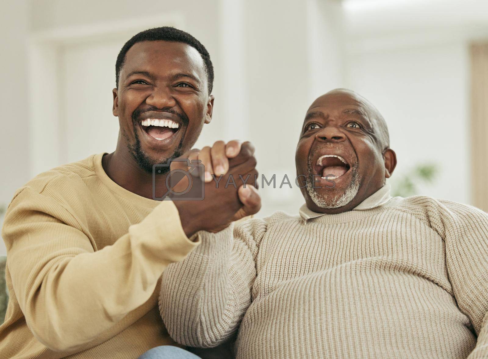 Royalty free image of Family means nobody gets left behind or forgotten. a father and son laughing in the lounge. by YuriArcurs