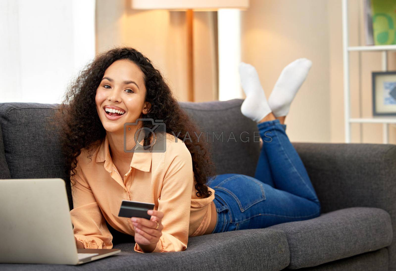 Royalty free image of Secure your order. a woman holding a credit card while using her laptop. by YuriArcurs